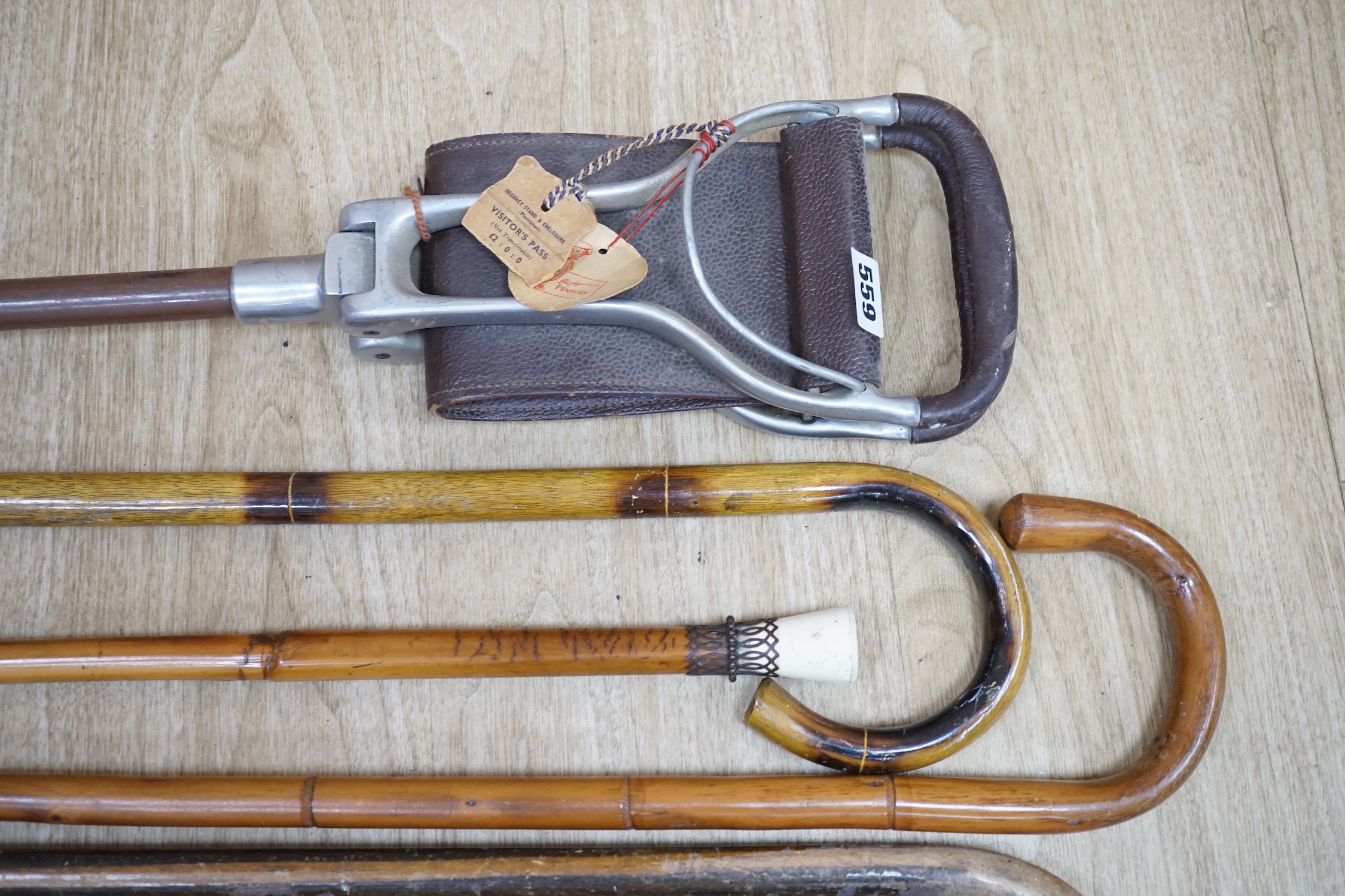 A group of eight various wood walking sticks including a carved ‘dog head’ stick, a cane and a shooting stick